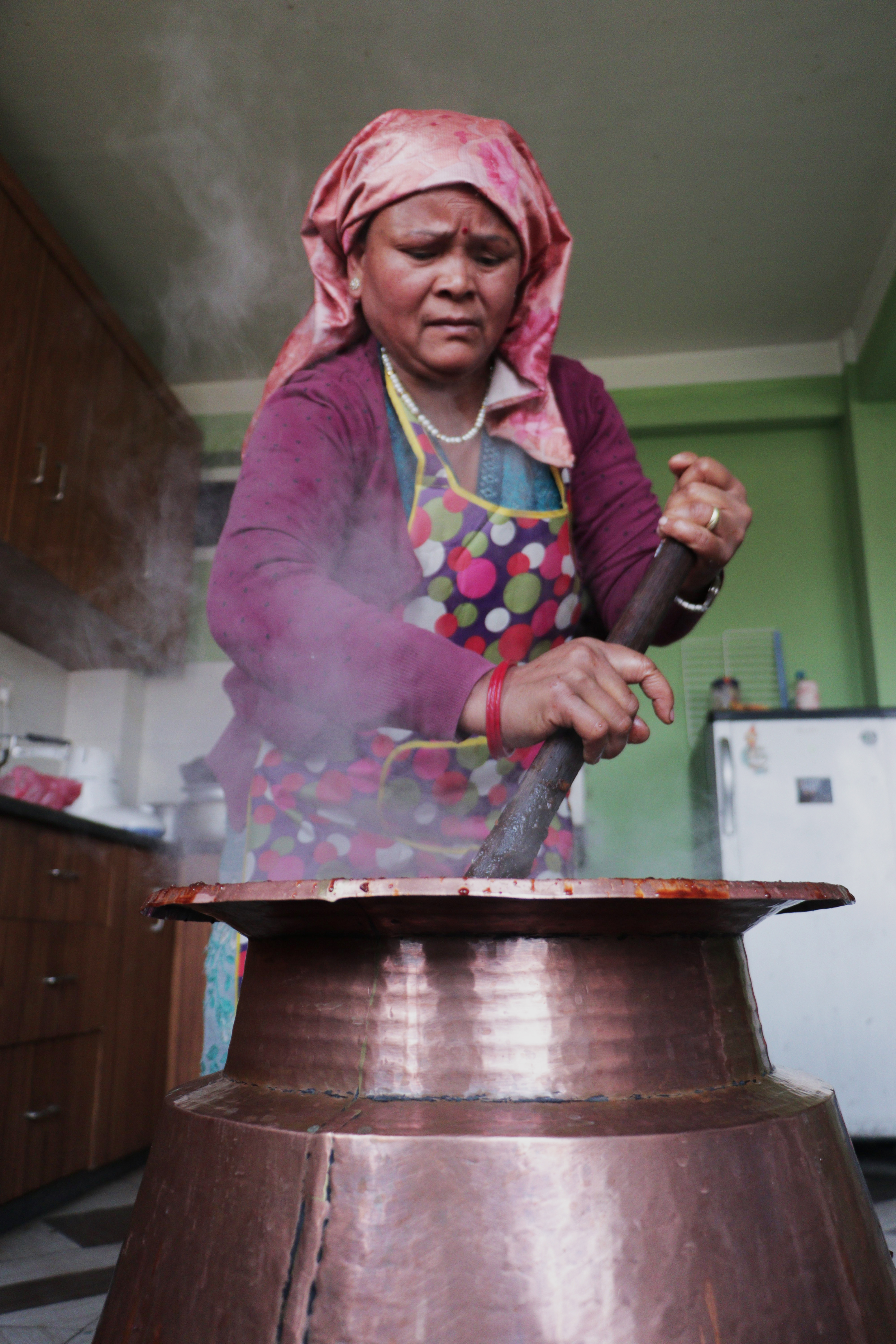 Shova Laxmi Gosai cooking Chaku Wasa: over a traditional copper cauldron in Bhaktapur